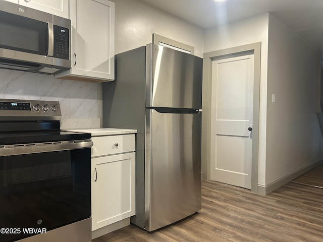 2401 Linn St, Williamsport, PA 17701 - kitchen with backsplash, white cabinets, appliances with stainless steel finishes, and dark wood-style floors