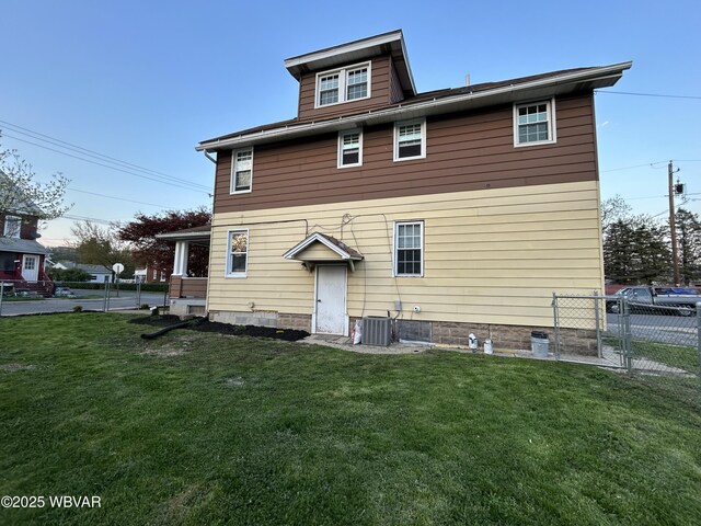 2401 Linn St, Williamsport, PA 17701 - rear view of house with central AC unit, fence, and a lawn