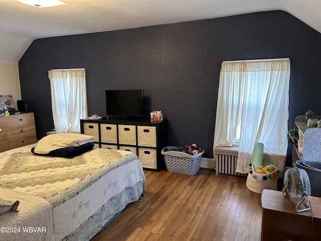 bedroom featuring radiator heating unit, hardwood / wood-style flooring, and lofted ceiling