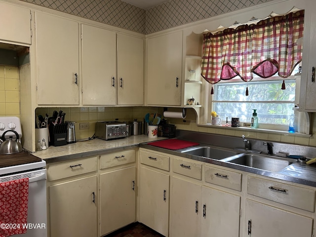 kitchen with white cabinets, white electric range, tasteful backsplash, and sink