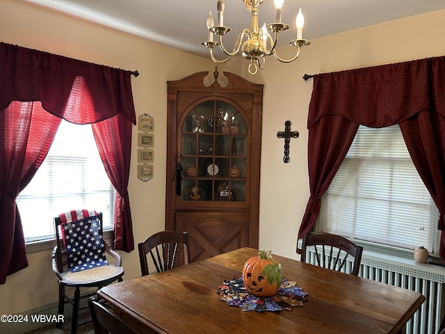 dining room with radiator and a chandelier