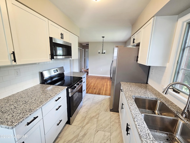 1760 Fredna Ave, Williamsport, PA 17701 - kitchen featuring stainless steel appliances, a sink, light marble finish floors, white cabinetry, and decorative backsplash