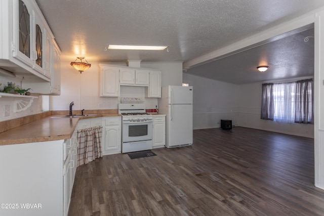 kitchen featuring sink, a textured ceiling, dark hardwood / wood-style floors, white appliances, and white cabinets