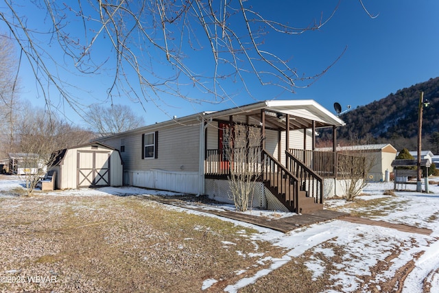 view of front of house featuring a porch and a storage shed