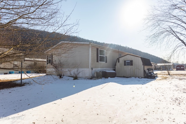 snow covered rear of property with cooling unit