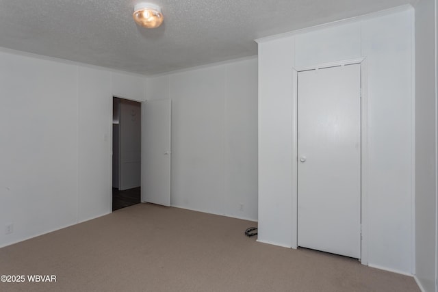 unfurnished bedroom with carpet floors, a textured ceiling, and a closet