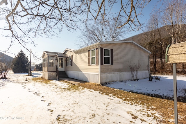 view of snowy exterior with a sunroom