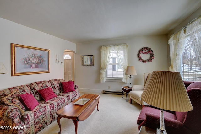 living room featuring light carpet, baseboards, arched walkways, and baseboard heating