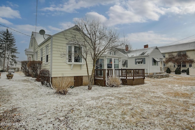 snow covered rear of property featuring a wooden deck