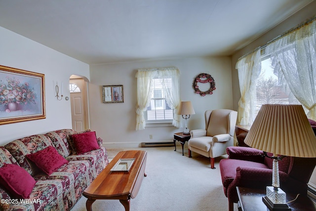 living area with carpet floors, arched walkways, and baseboards