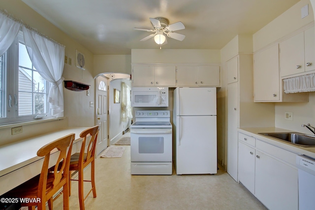 kitchen with ceiling fan, white appliances, a sink, white cabinets, and light countertops