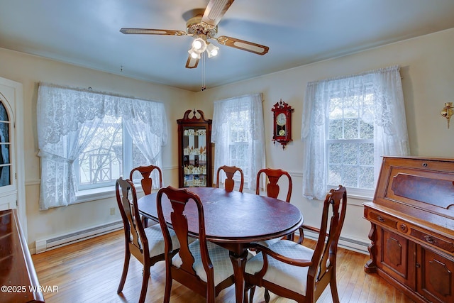 dining room featuring light wood-type flooring, baseboards, ceiling fan, and baseboard heating