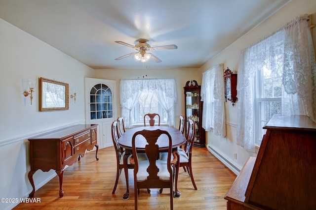 dining area featuring a baseboard radiator, a healthy amount of sunlight, ceiling fan, and light wood finished floors