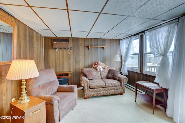 living area featuring a drop ceiling, a baseboard radiator, carpet floors, wood walls, and a wall mounted AC