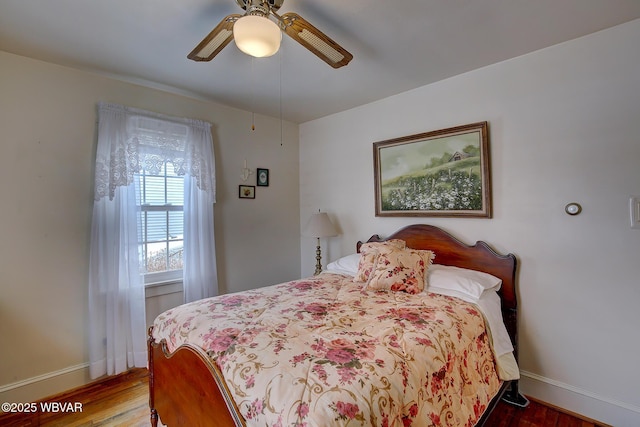 bedroom featuring ceiling fan, wood finished floors, and baseboards