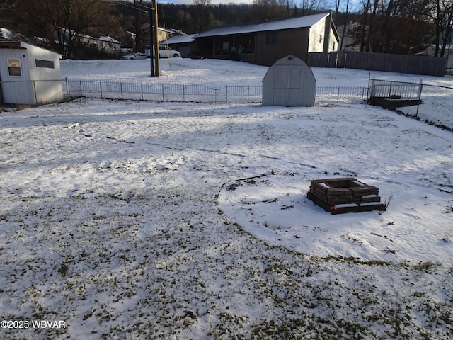 yard layered in snow with a storage shed