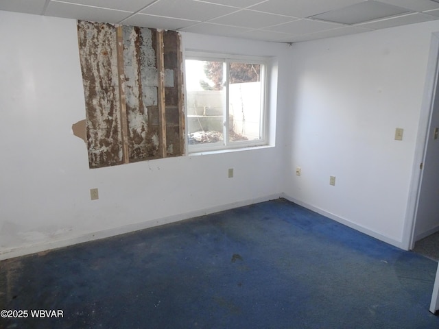 empty room with a paneled ceiling and dark carpet