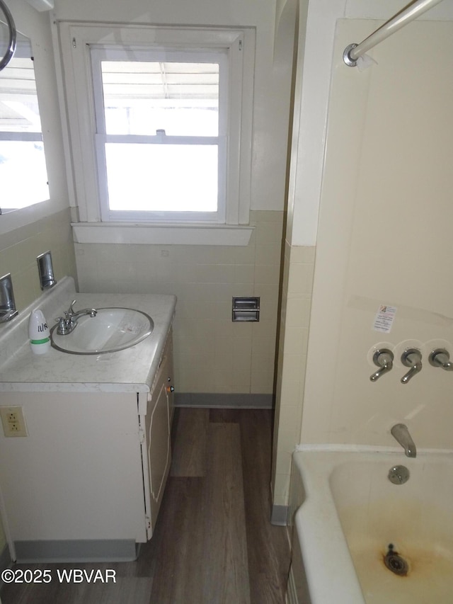 bathroom with vanity, shower / bath combination, tile walls, and hardwood / wood-style flooring