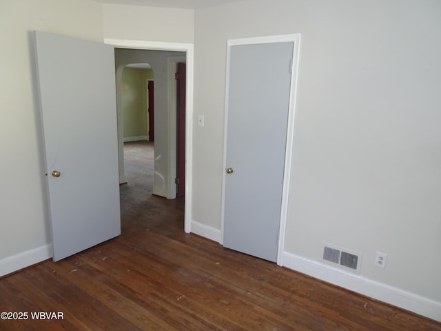 unfurnished room with dark wood-type flooring