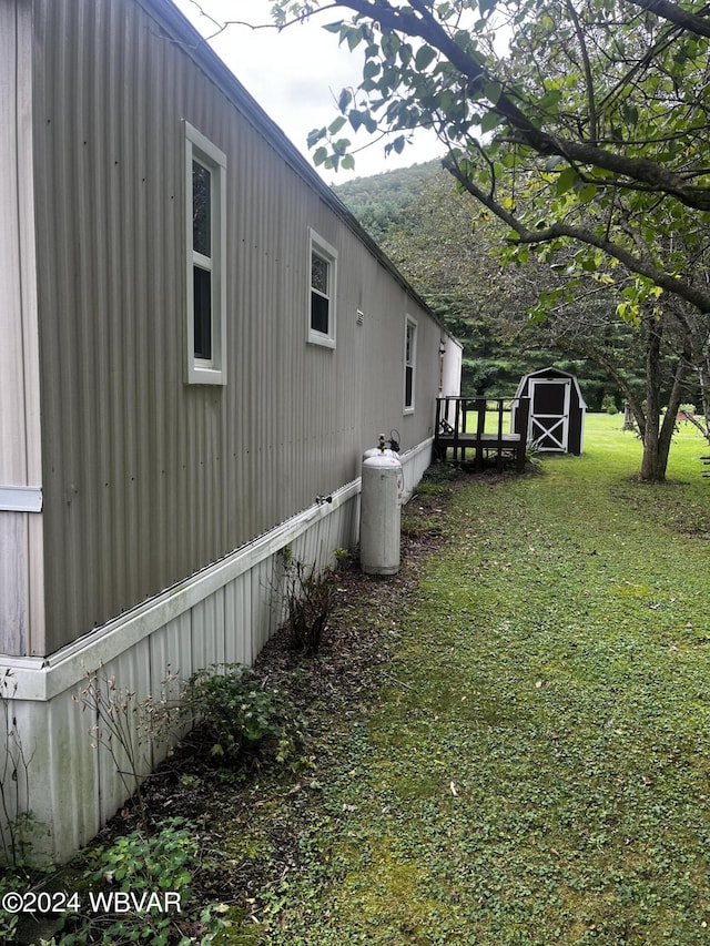 view of home's exterior with a lawn and a storage unit