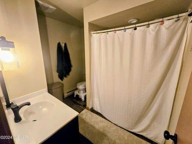 bathroom featuring vanity, a baseboard radiator, toilet, and hardwood / wood-style flooring