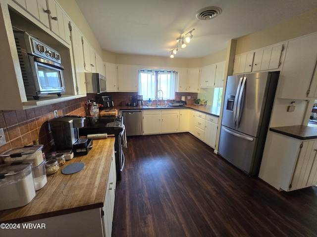 kitchen featuring dark hardwood / wood-style flooring, stainless steel appliances, and white cabinetry