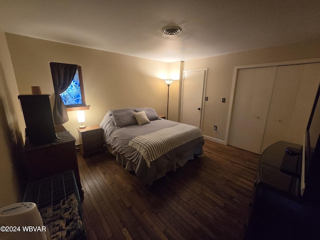 bedroom featuring dark hardwood / wood-style flooring and multiple closets