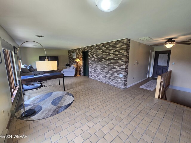 interior space with light tile patterned floors and ceiling fan