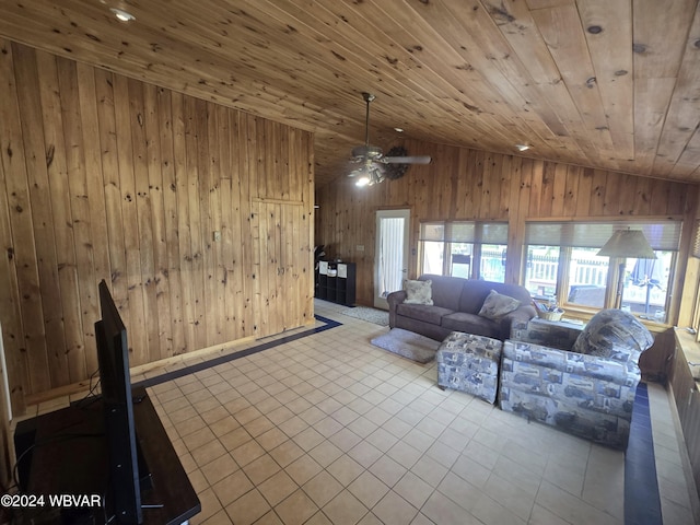 unfurnished living room featuring wood walls, wooden ceiling, vaulted ceiling, ceiling fan, and light tile patterned flooring