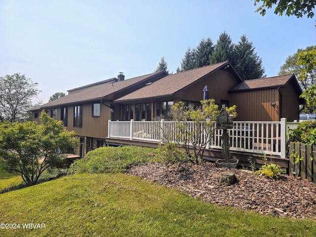 rear view of house with a yard and a wooden deck