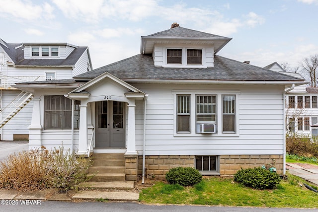 bungalow-style house featuring cooling unit, a chimney, and roof with shingles