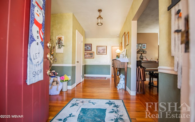 entryway with a fireplace, baseboards, and wood finished floors