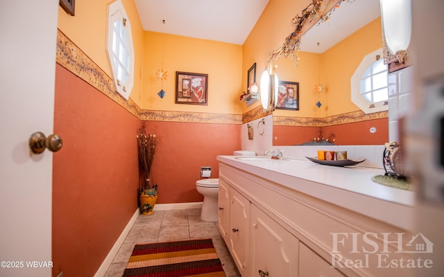 bathroom featuring tile patterned floors, wainscoting, toilet, and vanity