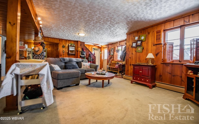 carpeted living area with wood walls and a baseboard radiator