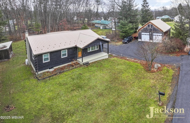 view of front of property featuring a garage, an outdoor structure, and a front lawn