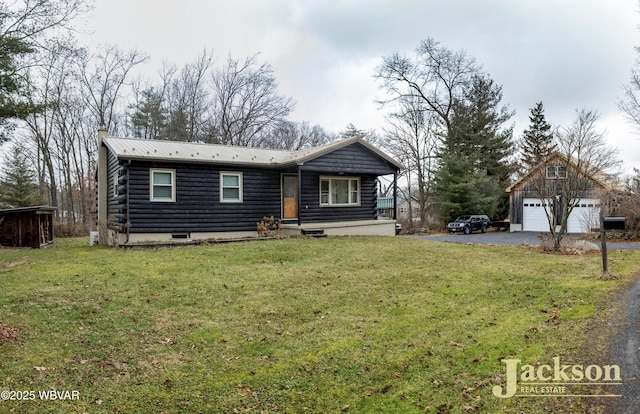 view of front of house with an outbuilding, a garage, and a front lawn