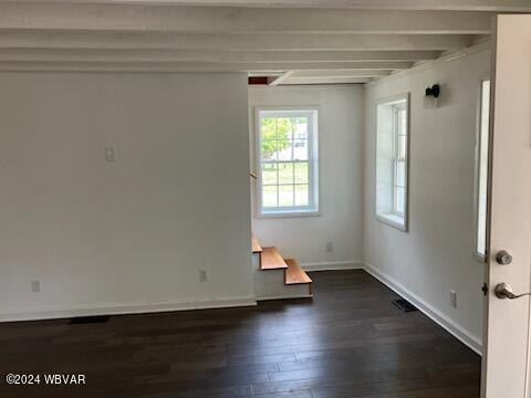 unfurnished room with dark wood-style floors, beam ceiling, and baseboards