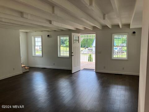 interior space featuring beam ceiling, baseboards, and dark wood-style flooring