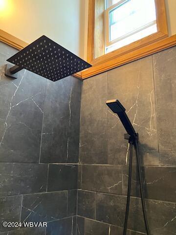 interior details featuring a tile shower