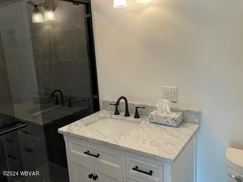 full bath with a shower stall, toilet, and vanity