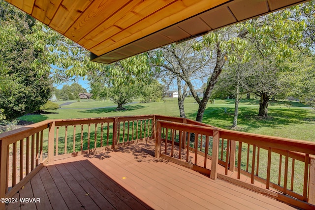 wooden deck featuring a lawn