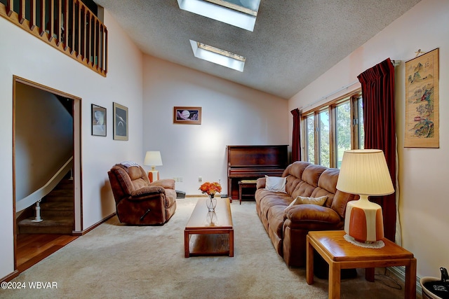 living room featuring vaulted ceiling with skylight, hardwood / wood-style floors, and a textured ceiling