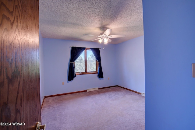 spare room with light carpet, a textured ceiling, and ceiling fan