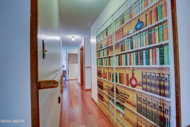 hallway featuring a textured ceiling and hardwood / wood-style flooring