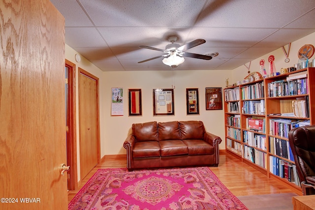 sitting room with a paneled ceiling, light hardwood / wood-style flooring, and ceiling fan