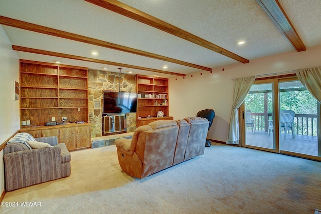 carpeted living room featuring beamed ceiling, built in shelves, and a textured ceiling