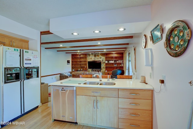 kitchen featuring kitchen peninsula, stainless steel dishwasher, white fridge with ice dispenser, and sink