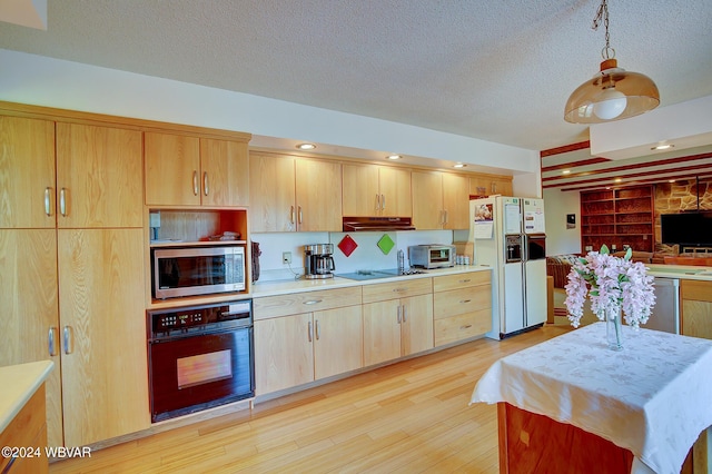 kitchen featuring pendant lighting, black appliances, light hardwood / wood-style flooring, a textured ceiling, and light brown cabinetry