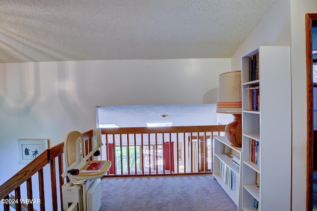 hall with carpet flooring, lofted ceiling, and a textured ceiling