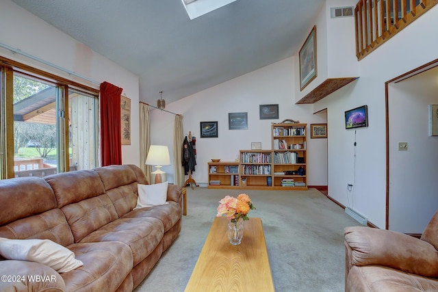 carpeted living room with a skylight and high vaulted ceiling